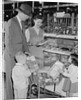 Family of 4 inside supermarket father pushing cart mother 2 kids by Anonymous