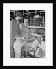 Family of 4 inside supermarket father pushing cart mother 2 kids by Anonymous