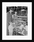 Family of 4 inside supermarket father pushing cart mother 2 kids by Anonymous