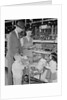 Family of 4 inside supermarket father pushing cart mother 2 kids by Anonymous