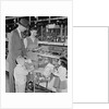 Family of 4 inside supermarket father pushing cart mother 2 kids by Anonymous