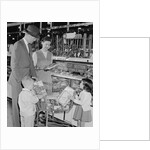 Family of 4 inside supermarket father pushing cart mother 2 kids by Anonymous