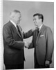 Older and younger business men shaking hands by Anonymous