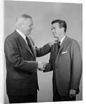 Older and younger business men shaking hands by Anonymous