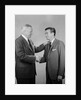 Older and younger business men shaking hands by Anonymous