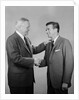 Older and younger business men shaking hands by Anonymous