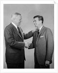 Older and younger business men shaking hands by Anonymous