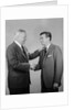 Older and younger business men shaking hands by Anonymous
