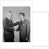 Older and younger business men shaking hands by Anonymous