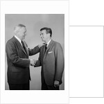 Older and younger business men shaking hands by Anonymous