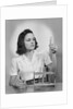 Young woman chemist holding up test tube by Anonymous