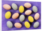 Small coloured Easter eggs on purple background by Anonymous
