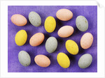 Small coloured Easter eggs on purple background by Anonymous