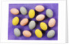 Small coloured Easter eggs on purple background by Anonymous