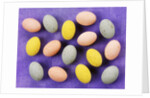 Small coloured Easter eggs on purple background by Anonymous