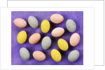 Small coloured Easter eggs on purple background by Anonymous