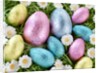 Chocolate Easter eggs in coloured foil in grass by Anonymous