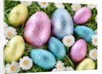 Chocolate Easter eggs in coloured foil in grass by Anonymous