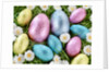 Chocolate Easter eggs in coloured foil in grass by Anonymous
