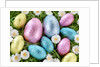 Chocolate Easter eggs in coloured foil in grass by Anonymous