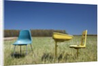 Abandoned school desk anc chairs in field by Anonymous