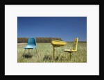 Abandoned school desk anc chairs in field by Anonymous