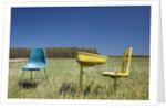 Abandoned school desk anc chairs in field by Anonymous