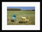 Abandoned school desk and chairs in farmer's field by Anonymous