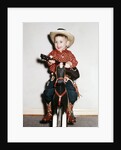 Little boy cowboy plays guitar while riding his horse, ca. 1956 by Anonymous