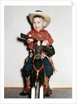 Little boy cowboy plays guitar while riding his horse, ca. 1956 by Anonymous