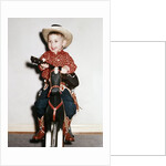 Little boy cowboy plays guitar while riding his horse, ca. 1956 by Anonymous