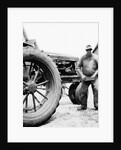 Farmer is a blur of activity working on his tractor, ca. 1938 by Anonymous