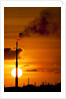 Flames and smoke billow from natural gas flare at Valero Oil Refinery at sunset by Anonymous