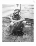 Boy sitting a very small wagon, ca. 1938 by Anonymous