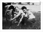 Young men change a tire on an automobile, ca. 1918 by Corbis