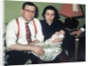 Young couple holding baby boy in christening gown, ca. 1952 by Anonymous