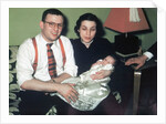 Young couple holding baby boy in christening gown, ca. 1952 by Anonymous
