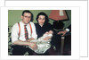 Young couple holding baby boy in christening gown, ca. 1952 by Anonymous