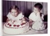 Brother watches his sister blow out candles on birthday cake, ca. 1956 by Anonymous