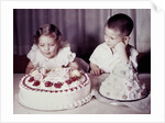 Brother watches his sister blow out candles on birthday cake, ca. 1956 by Anonymous