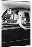 Young boy hangs out of driver's side car window, ca. 1954 by Anonymous
