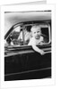 Young boy hangs out of driver's side car window, ca. 1954 by Anonymous