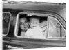 Mother holds crying son in her lap in car, ca. 1954 by Anonymous