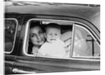 Mother holds crying son in her lap in car, ca. 1954 by Anonymous