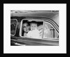 Mother holds crying son in her lap in car, ca. 1954 by Anonymous