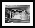 Mother holds crying son in her lap in car, ca. 1954 by Anonymous