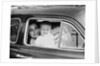 Mother holds crying son in her lap in car, ca. 1954 by Anonymous