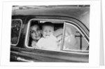 Mother holds crying son in her lap in car, ca. 1954 by Anonymous