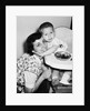 Baby boy hugging mother at dinner time, ca. 1953 by Anonymous