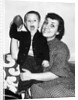 Little boy holding football with his mother, ca. 1955 by Anonymous